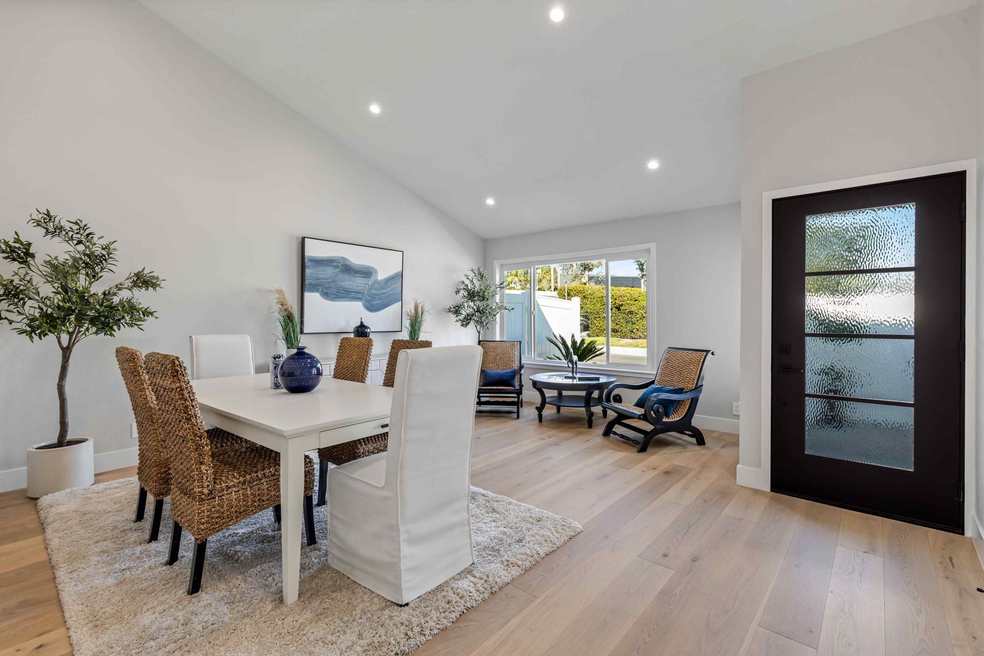 Dining room with a table, chairs, and sitting area next to a window.