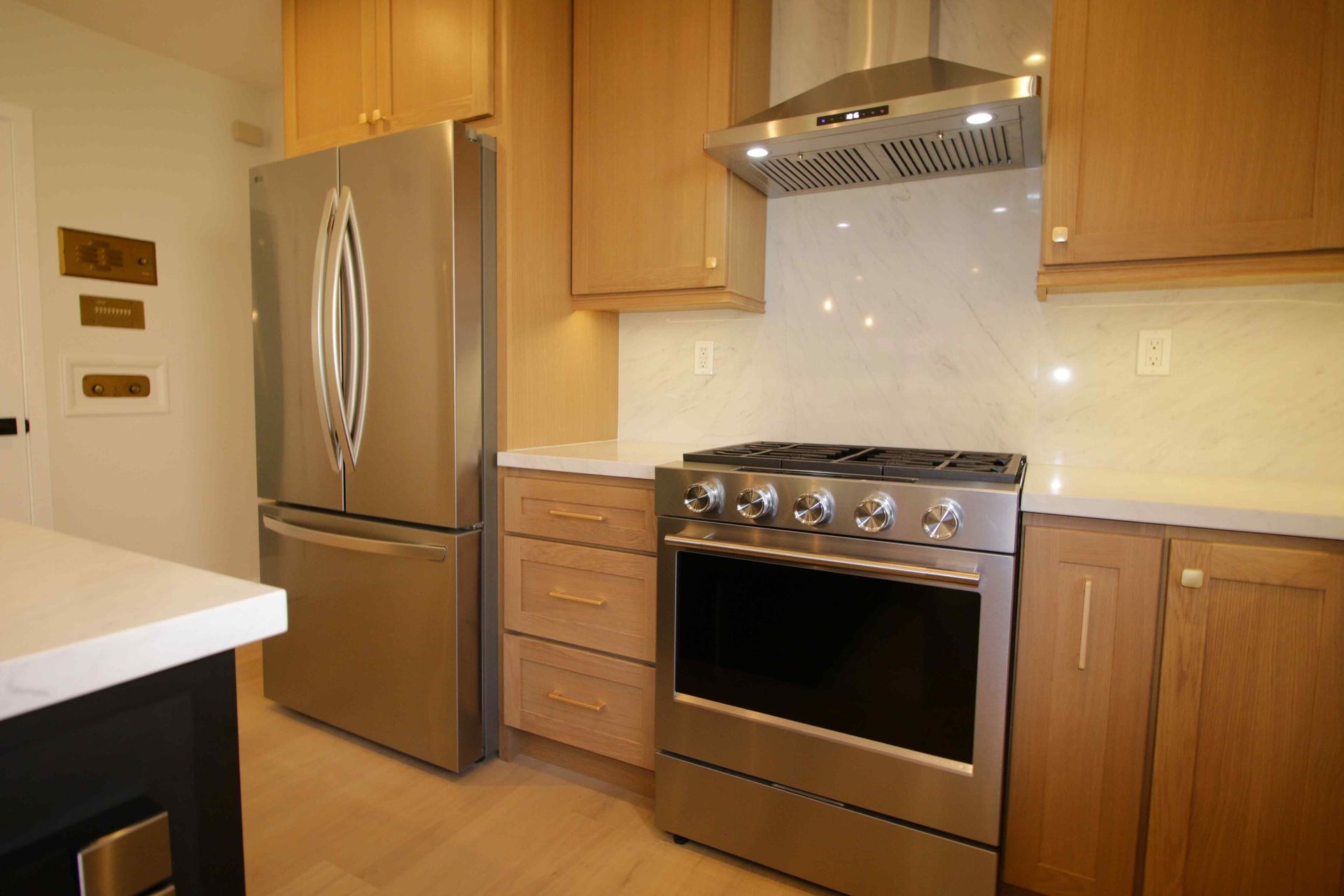 Modern kitchen with stainless steel refrigerator, stove, and wooden cabinets
