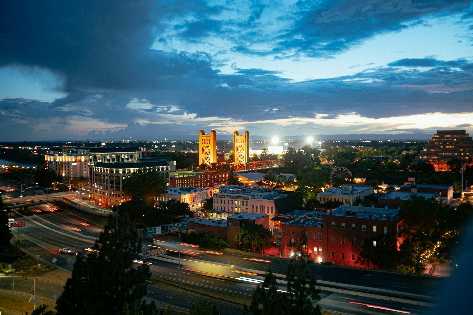 Night view of Sacramento, California with illuminated capitol building under a dusky blue sky.
