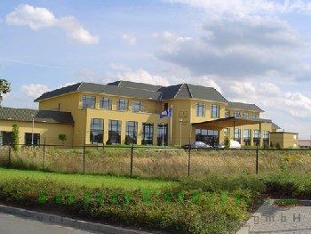 Ein großes gelbes Gebäude mit einem Zaun davor
