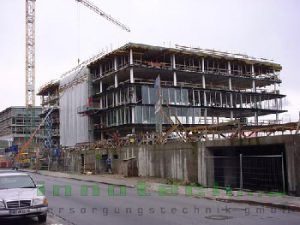 Ein Auto ist vor einem großen Gebäude im Bau geparkt.