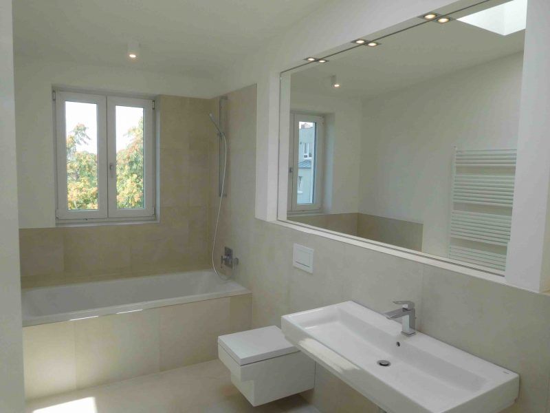 Ein Badezimmer mit Waschbecken, Toilette, Badewanne und Spiegel.