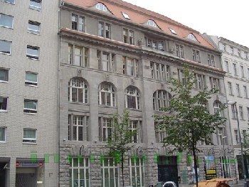 Ein großes Gebäude mit einem roten Dach und vielen Fenstern