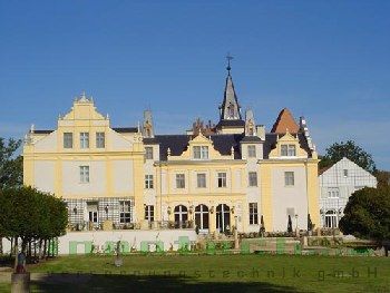 Ein großes gelb-weißes Schloss mit einem Turm darauf