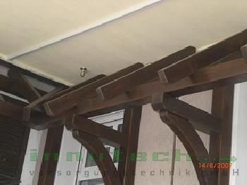 Eine Nahaufnahme einer Holzkonstruktion mit einer Decke im Hintergrund.