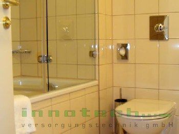 Ein Badezimmer mit Toilette, Badewanne und Dusche.