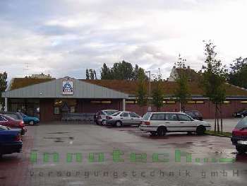 Ein Parkplatz mit vor einem Geschäft geparkten Autos.