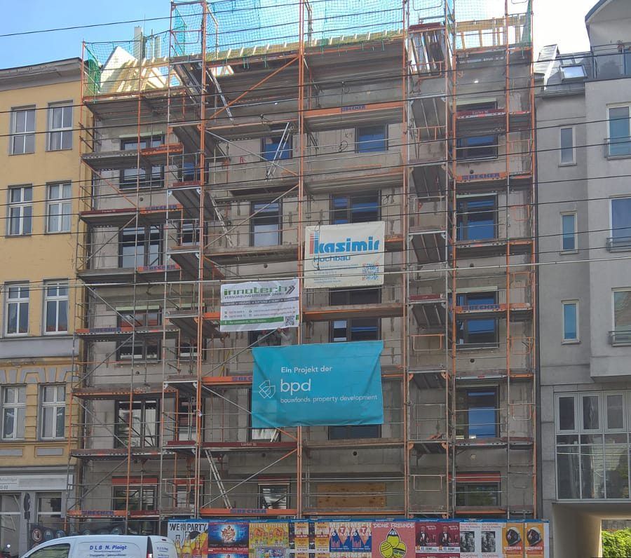 Ein im Bau befindliches Gebäude mit Gerüsten und einem Schild mit der Aufschrift „bpd“