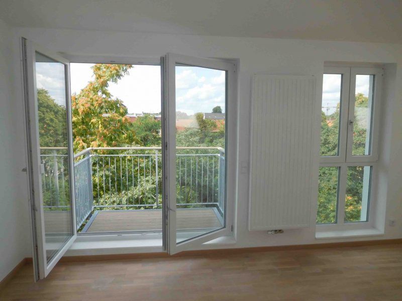 Ein leerer Raum mit Balkon und Glasschiebetür