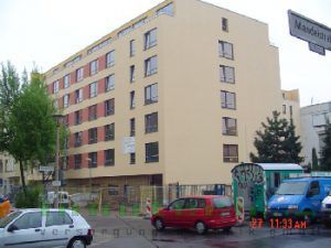 Ein roter Lieferwagen steht vor einem großen Gebäude