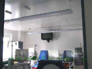 Ein Krankenhauszimmer mit einem Fernseher, der von der Decke hängt.