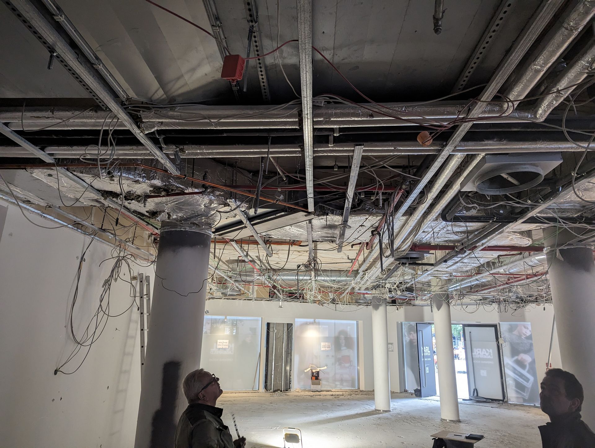 Ein Mann steht in einem Raum, von dessen Decke viele Kabel hängen.