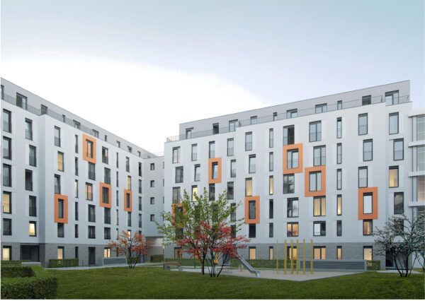 Ein großes Wohnhaus mit einem Spielplatz davor