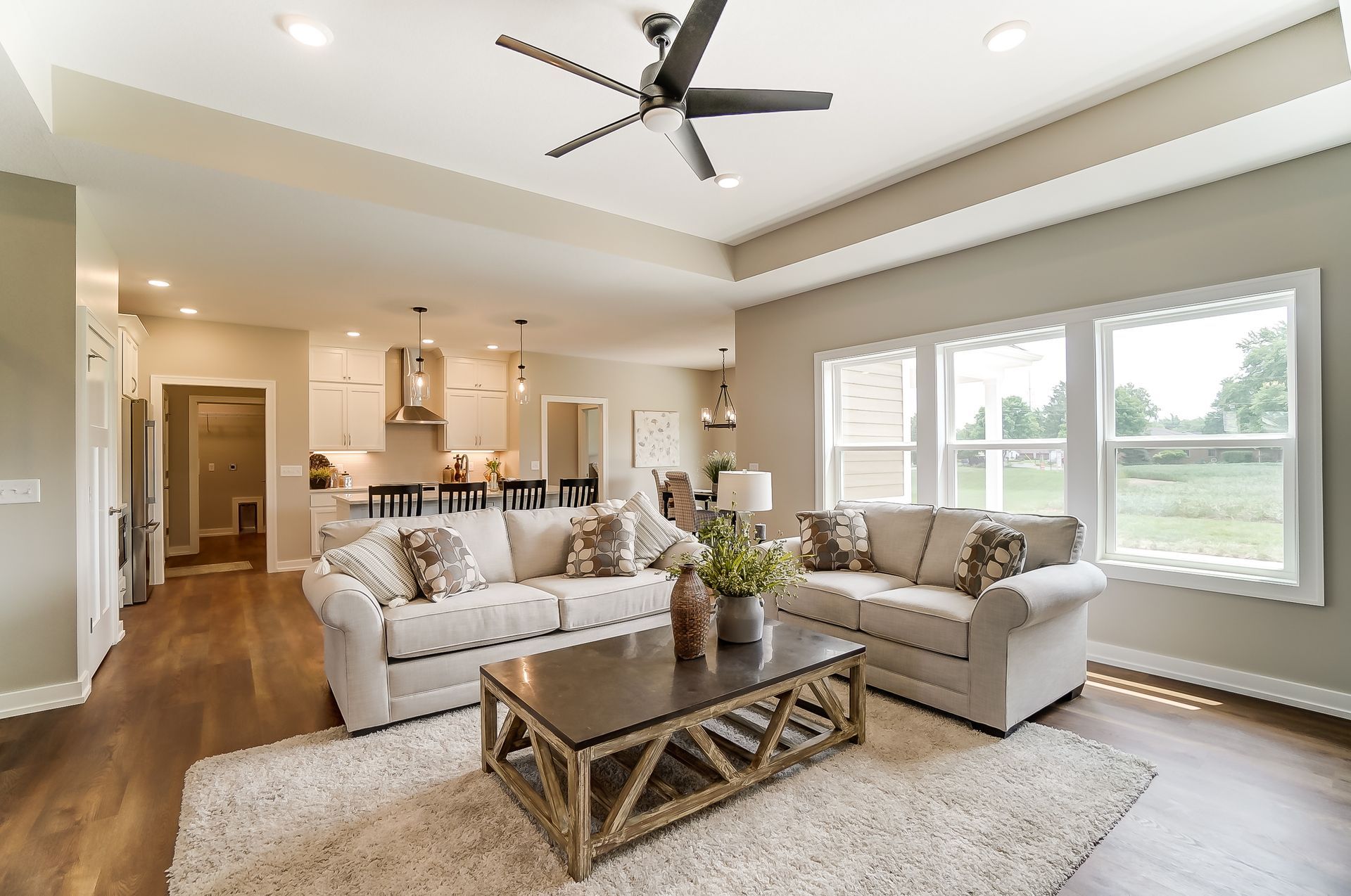 A living room with two couches , a coffee table , and a ceiling fan.