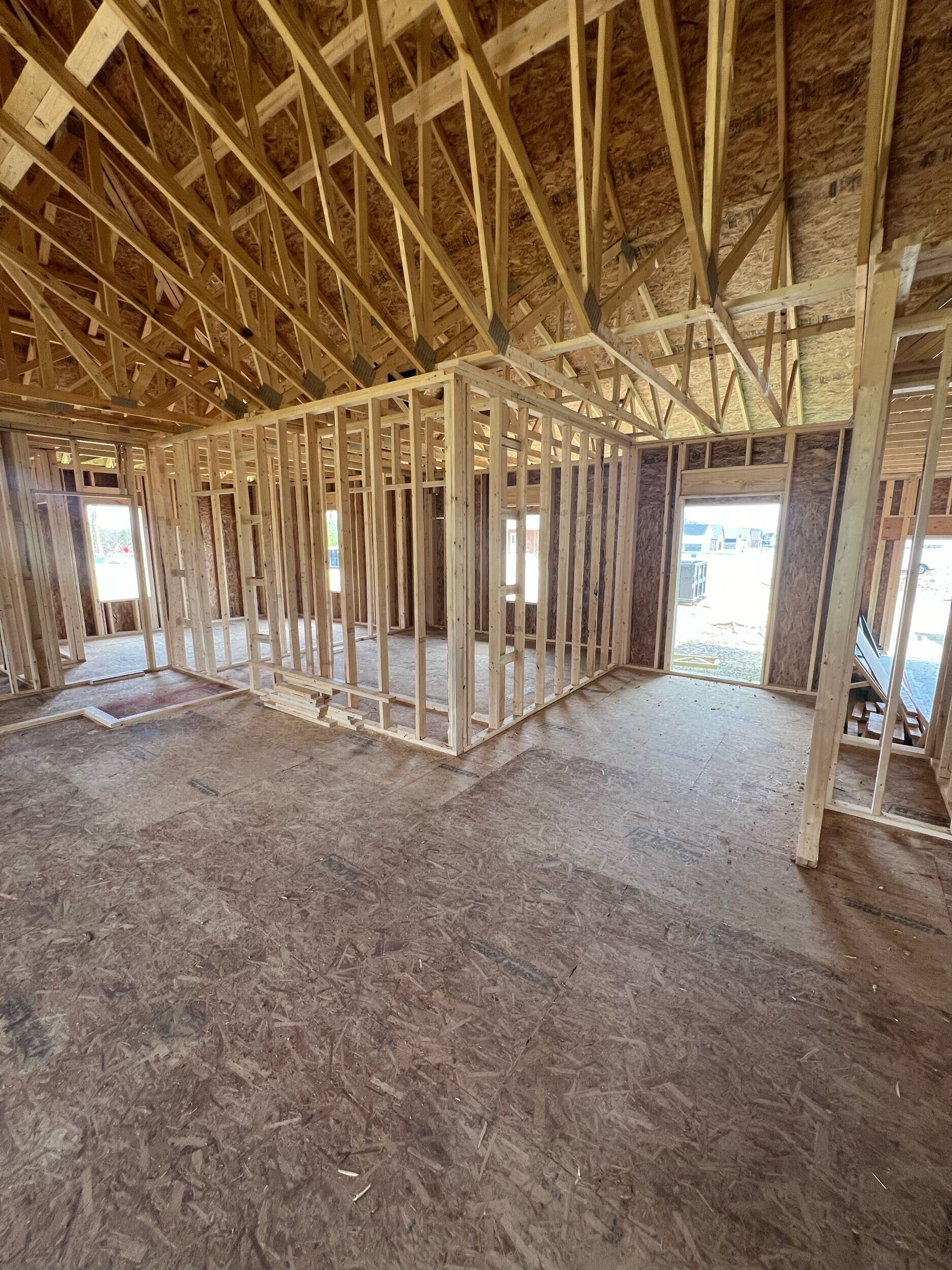 The inside of a house under construction with a lot of wooden beams.