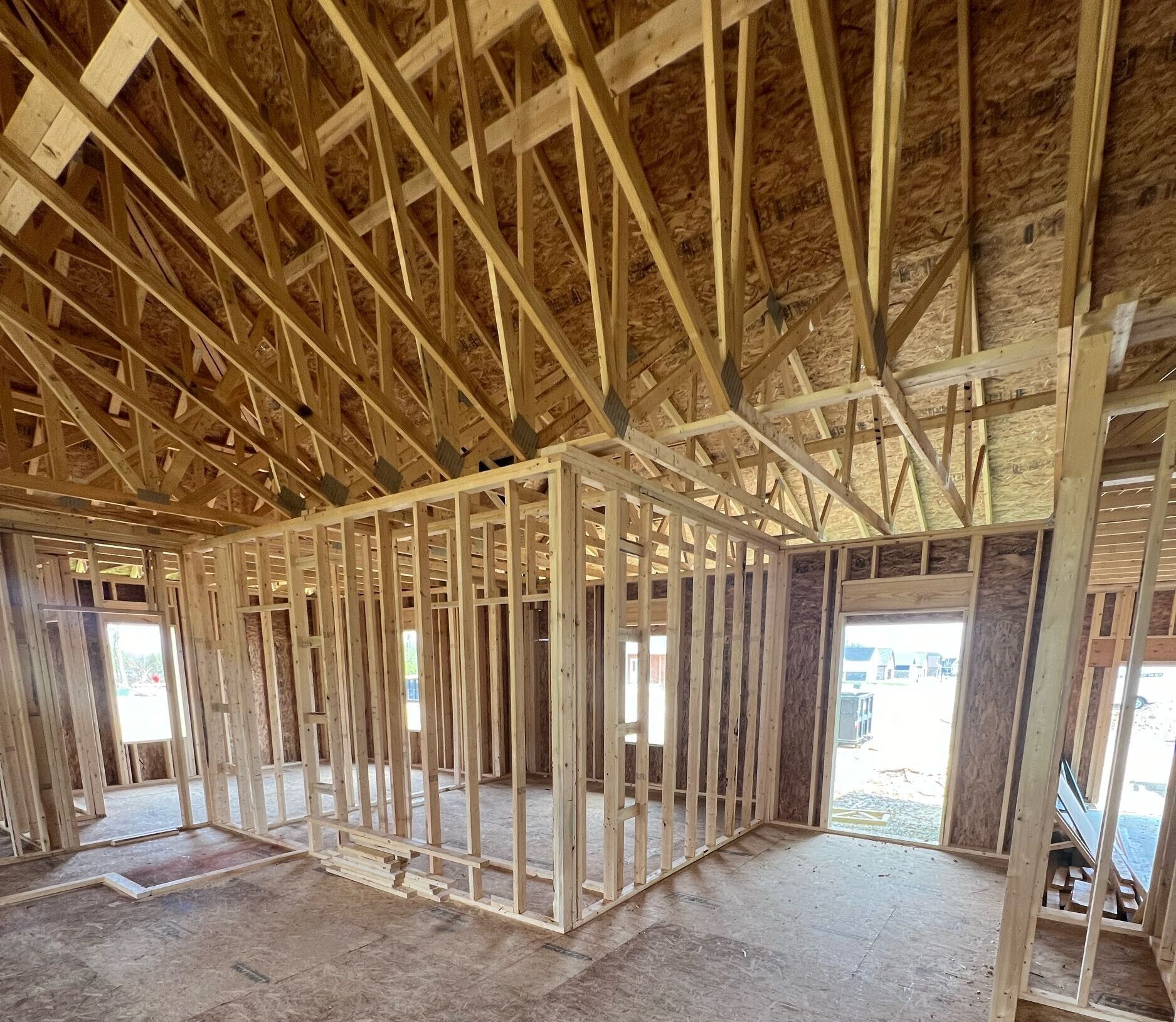 A room in a house under construction with wooden beams.