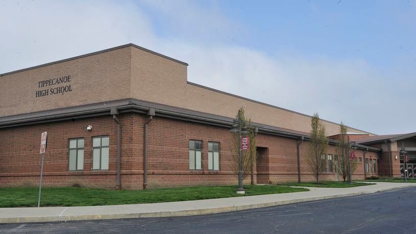 A large brick building with a lot of windows and a sidewalk in front of it.