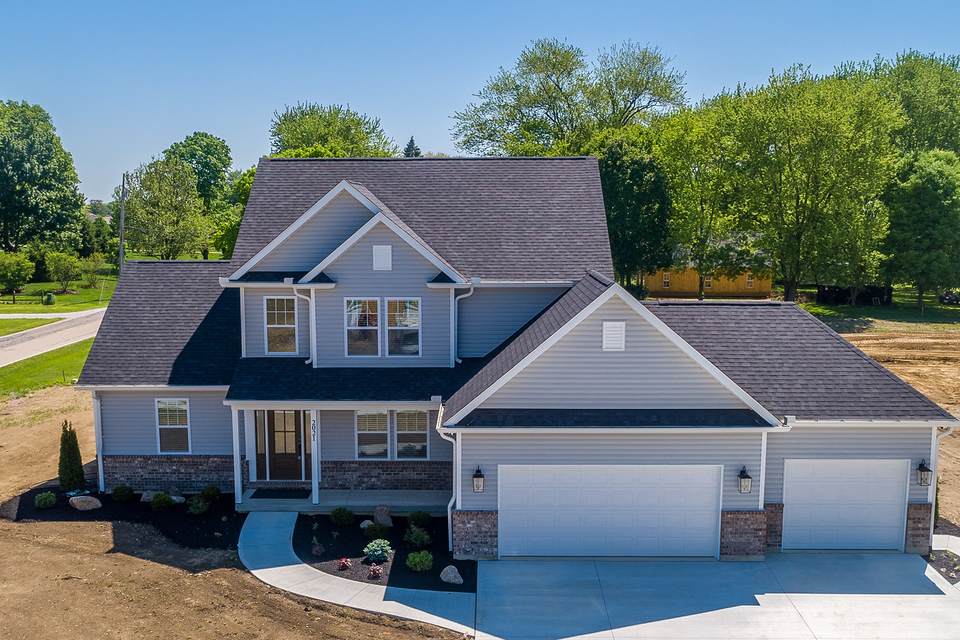 An aerial view of a large house with a black roof