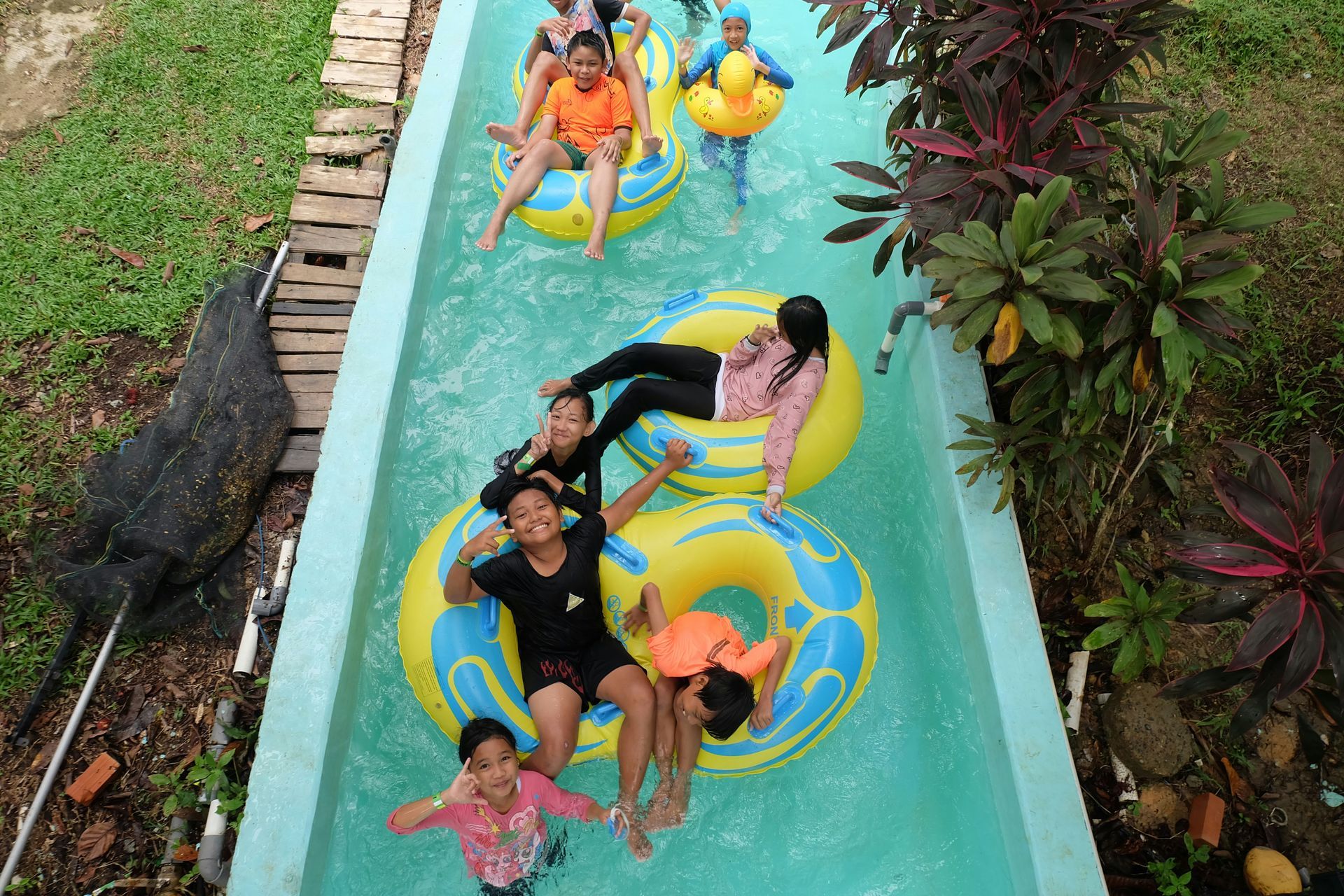 A group of children are floating down a water slide.