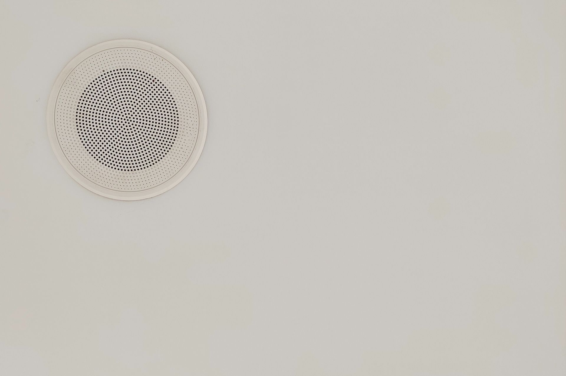 Ceiling-mounted commercial speaker for a paging or public address system installed in a commercial 