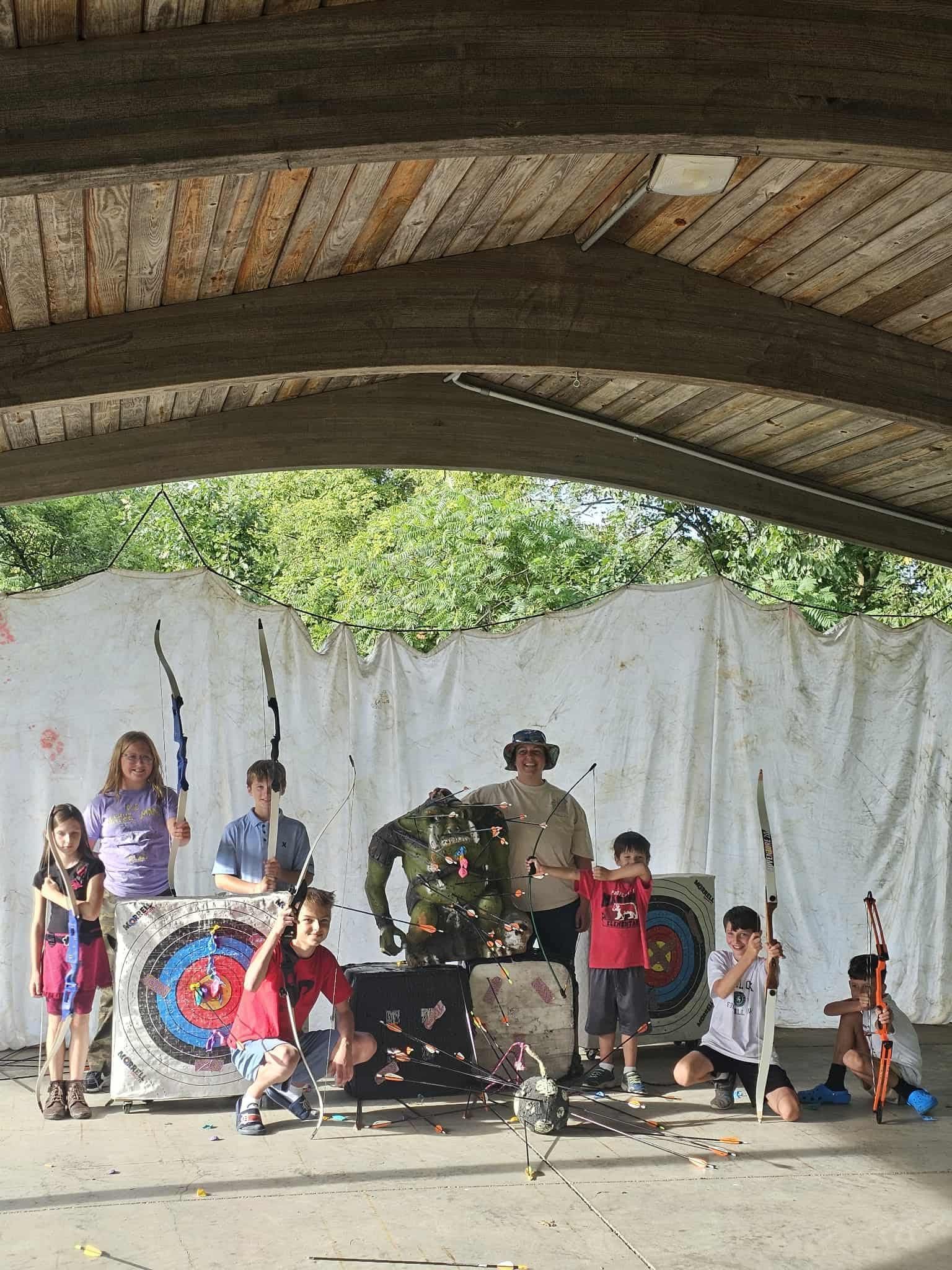 Outdoor stage performance with children in colorful outfits and drums under a pavilion