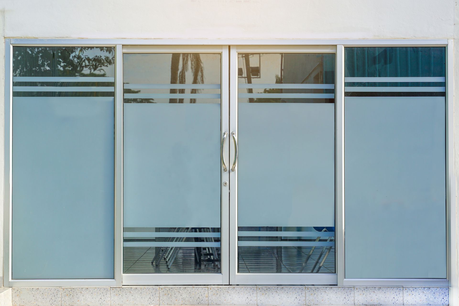 Four-pane frosted glass window with silver metal frame and centered handles