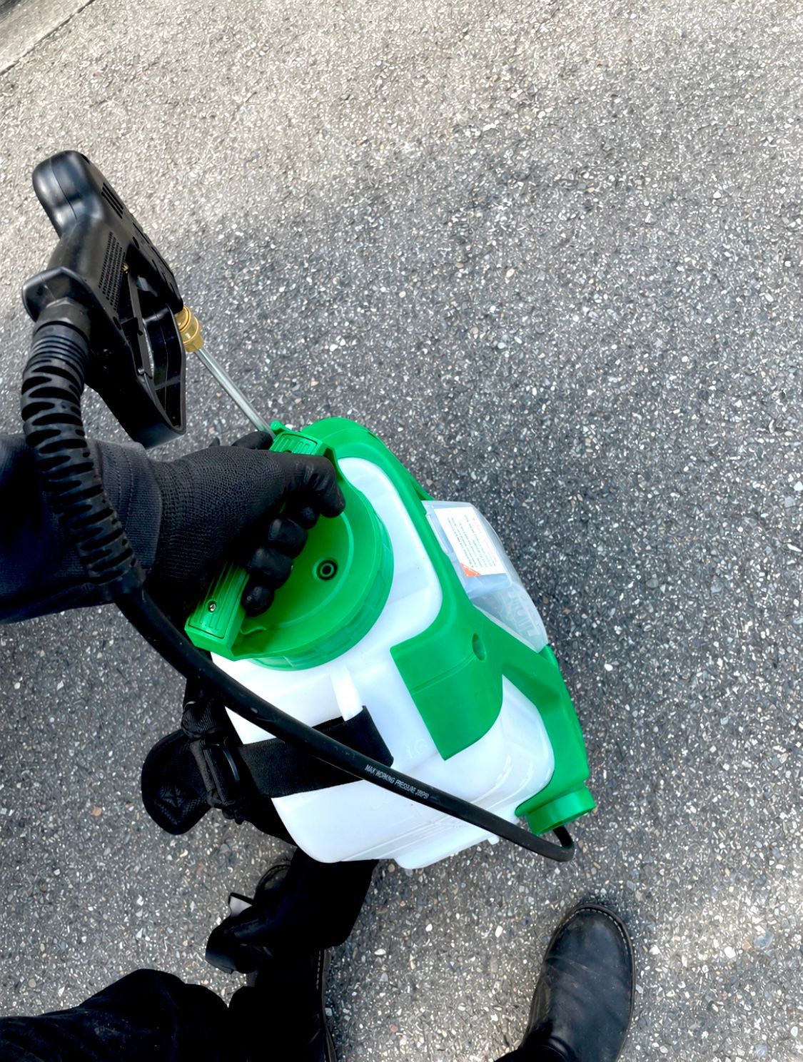 technician holding a battery operated sprayer