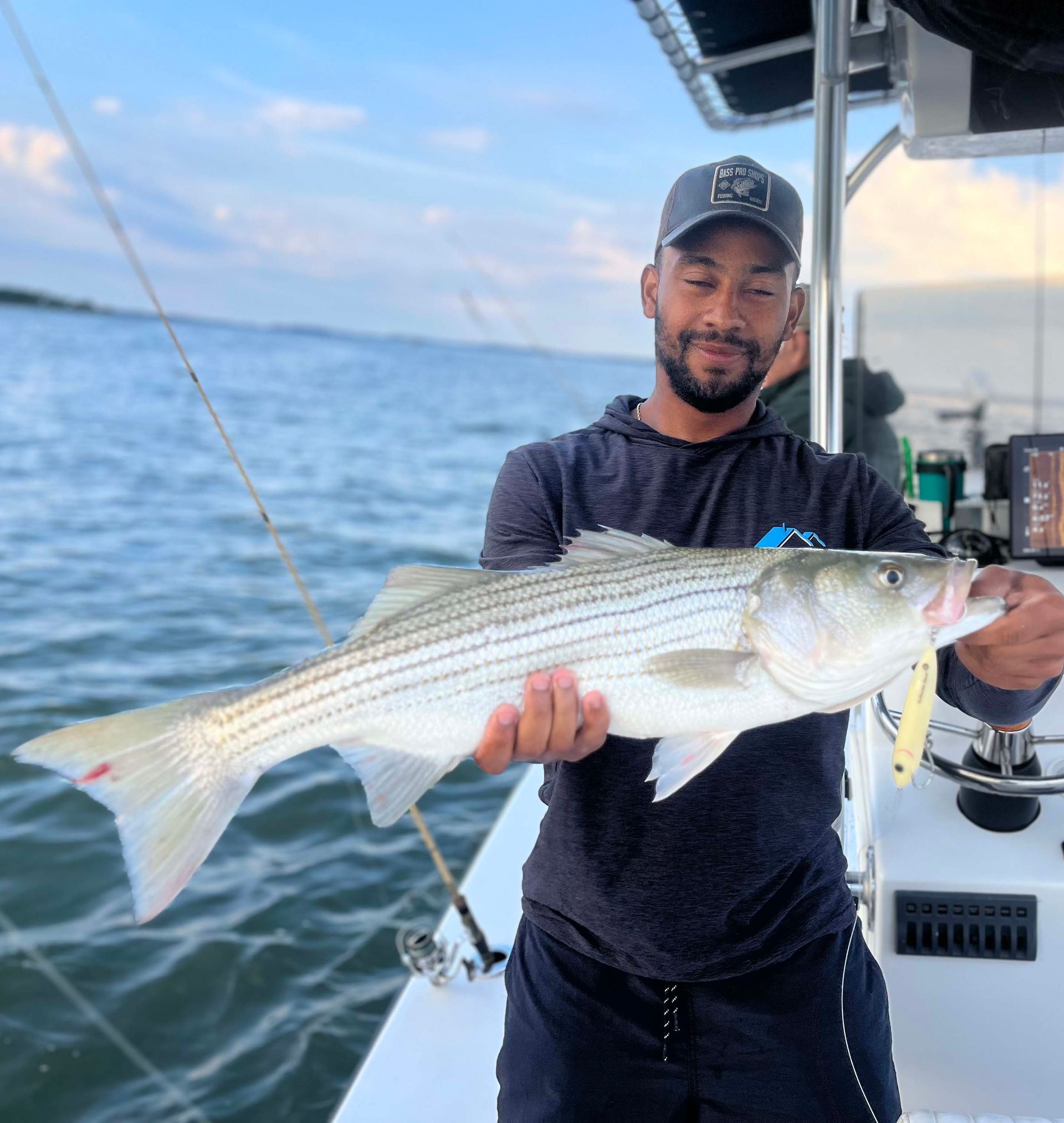 A man is holding a large fish on a boat.