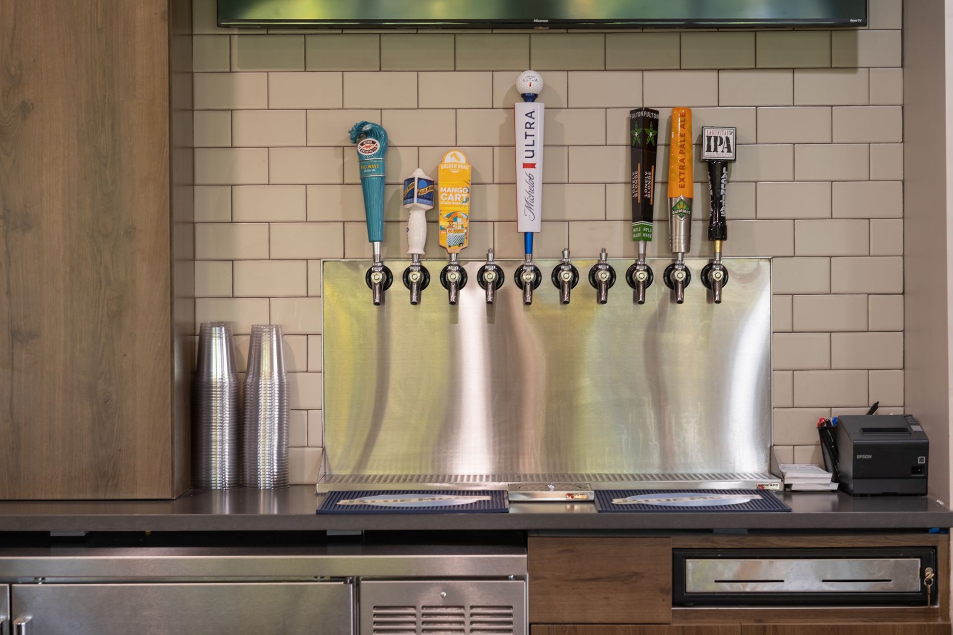 A bar with a bunch of beer taps hanging on the wall