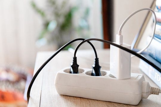 A power strip with a bunch of wires plugged into it on a table.