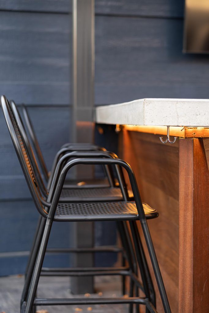 A row of chairs stacked on top of each other next to a wooden counter.