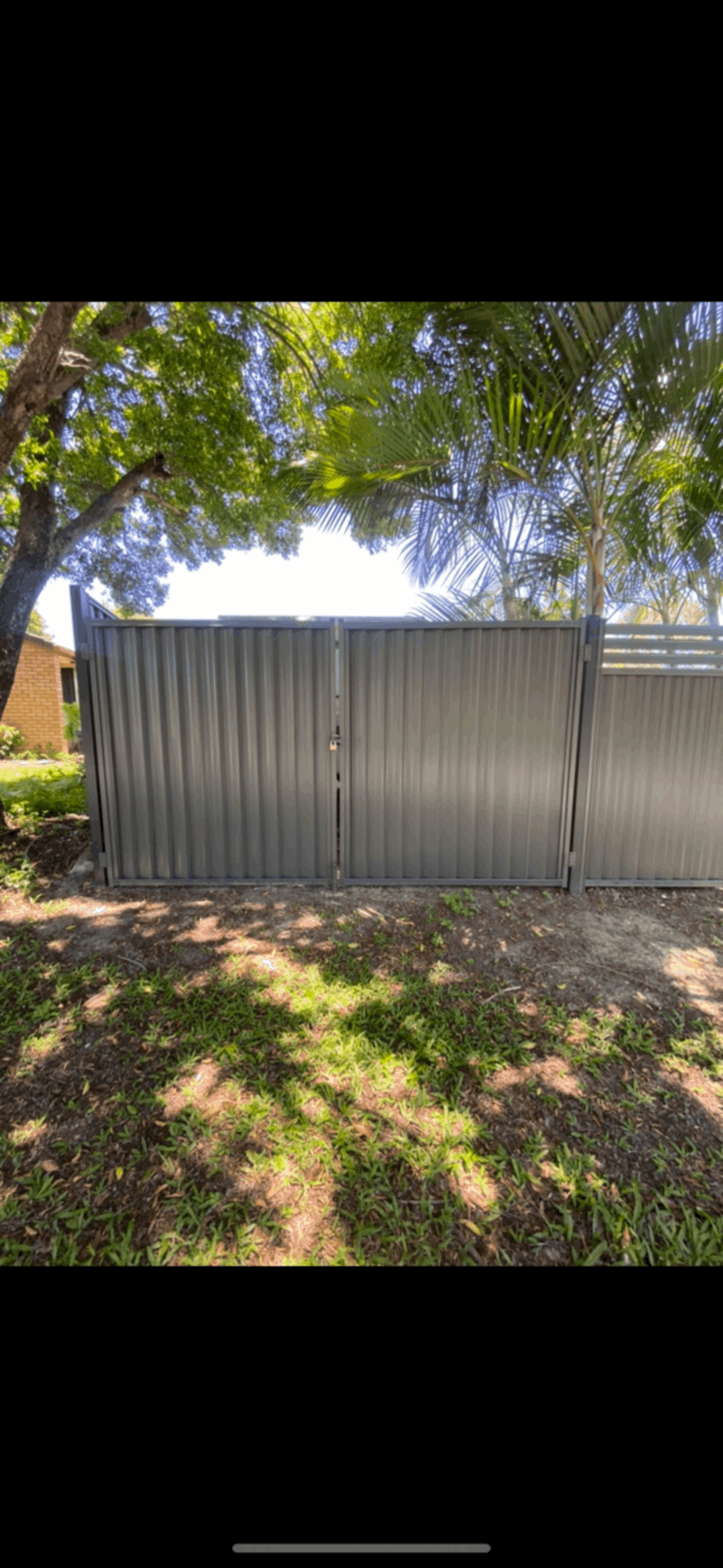 A black fence is sitting next to a brick building.