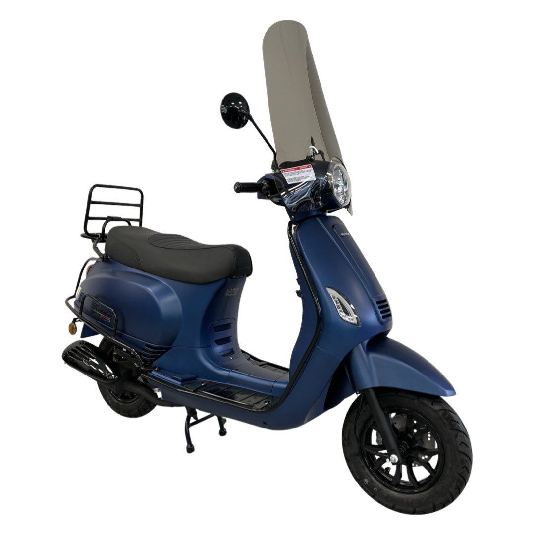 Blauwe scooter met voorruit, geparkeerd op een ondergrond. Met bagagerek achterop.