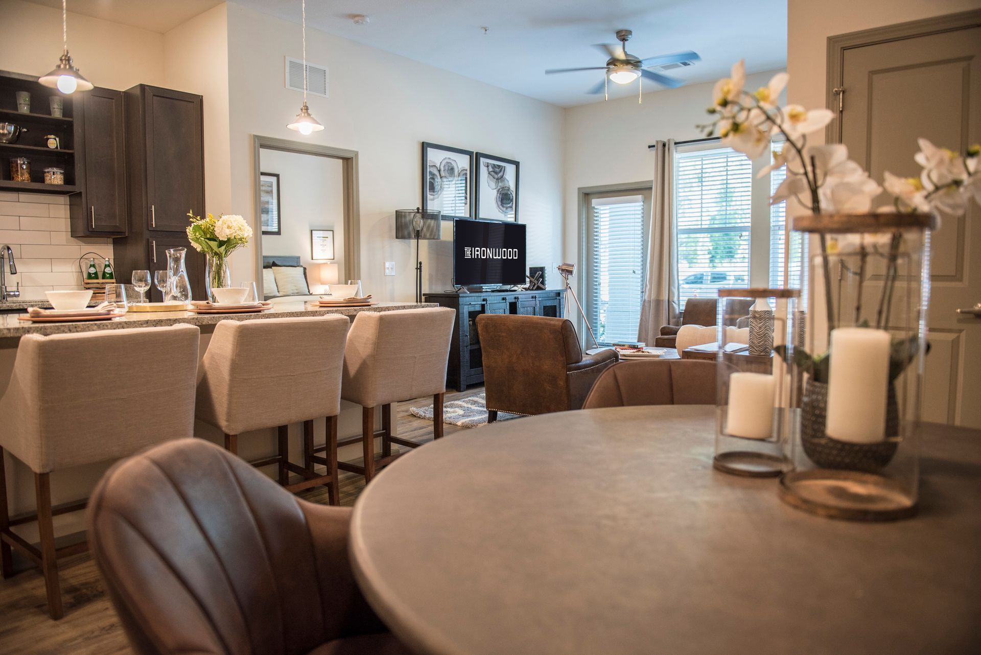 Interior of a well-lit living space with kitchen and dining area. Neutral color scheme, with focus on furniture and decor at Ironwood Apartment Homes.