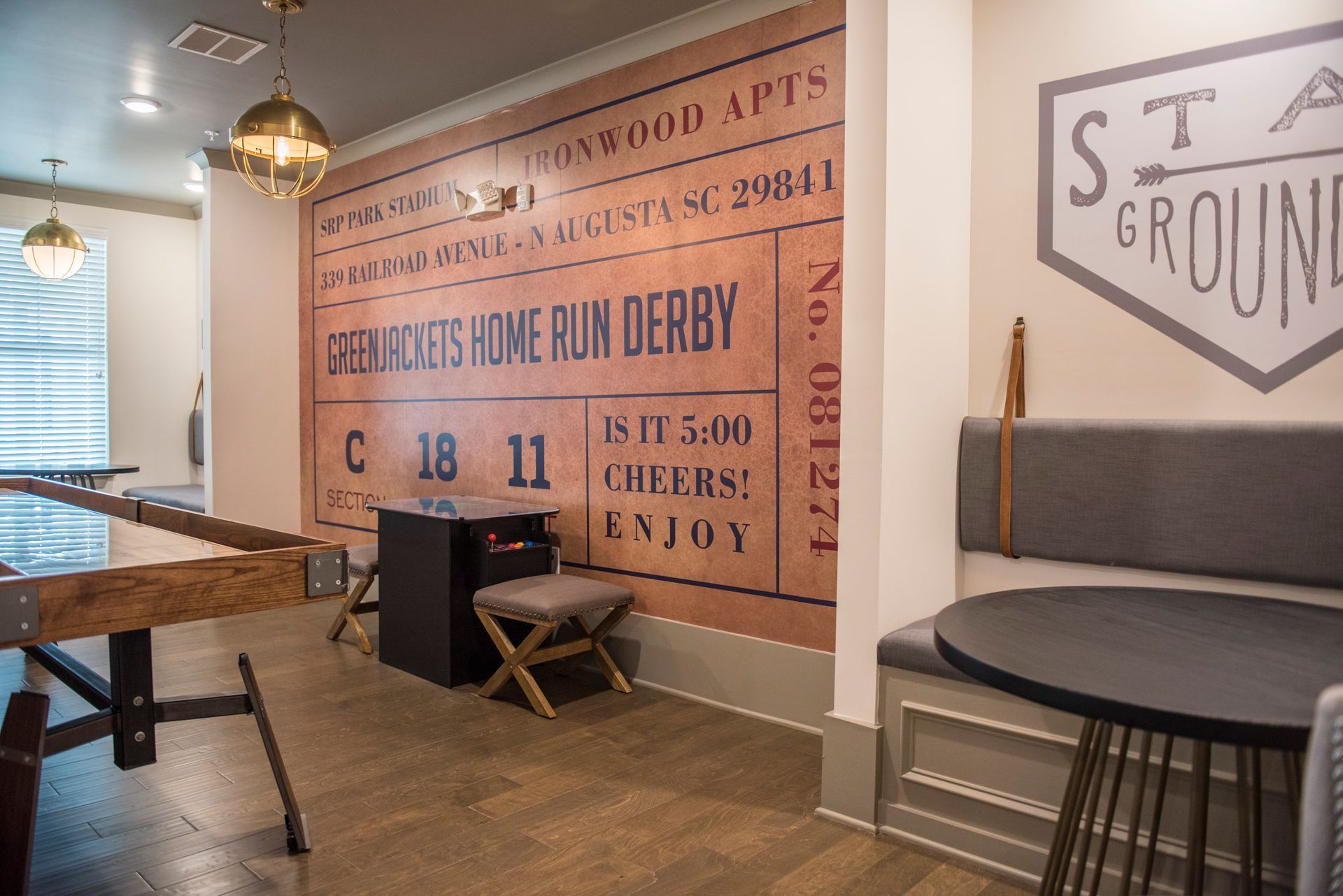 Game room with a foosball table, a wall mural, and seating at Ironwood Apartment Homes.
