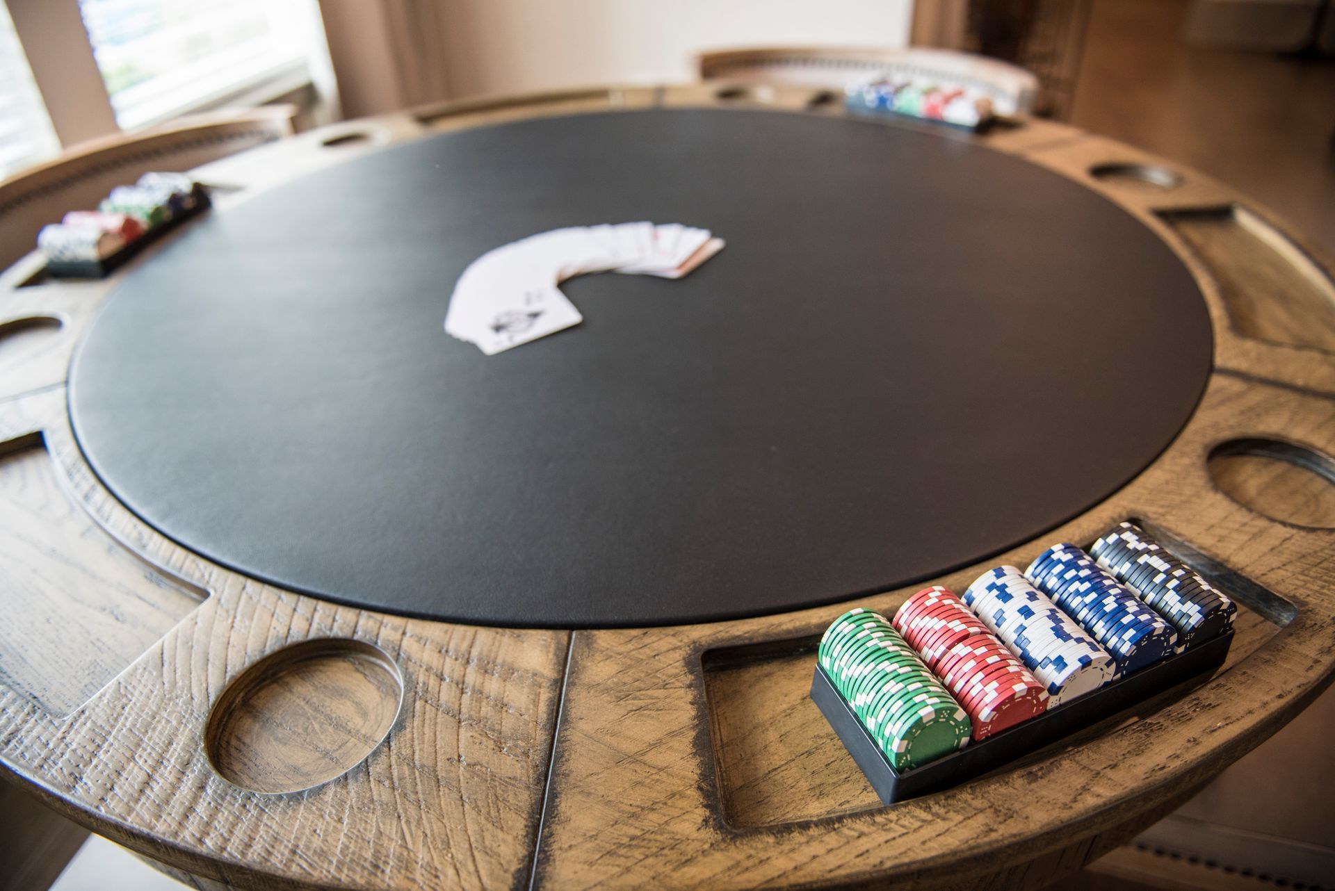 Poker table with cards and chips in a well-lit room at Ironwood Apartment Homes.