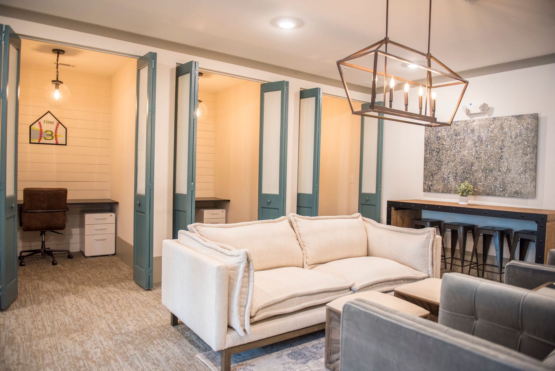 Cozy office with booths, couches, and a large light fixture at Ironwood Apartment Homes.