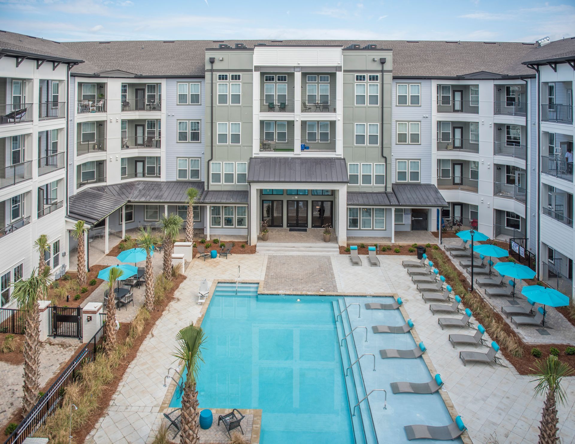 Aerial view of apartment complex with pool and lounge chairs at Ironwood Apartment Homes.