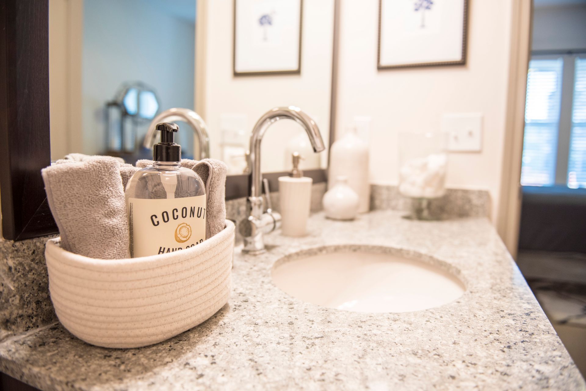 Bathroom sink with towels, soap, and decorations on a granite countertop at Ironwood Apartment Homes.