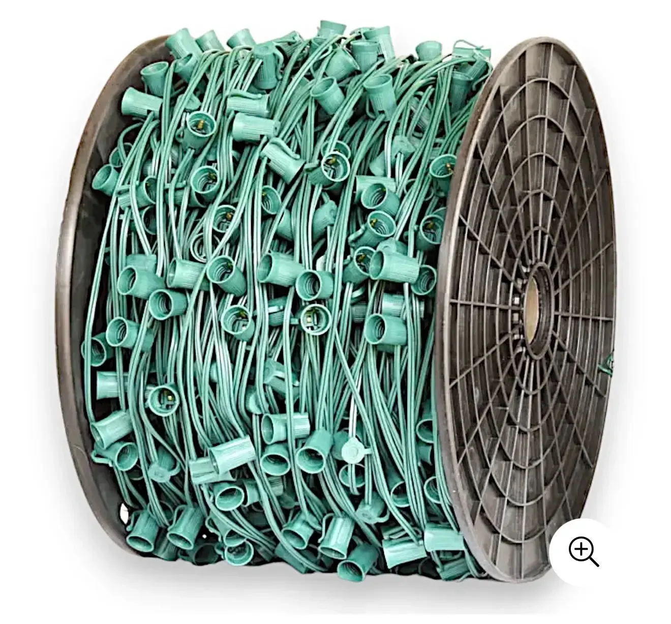 Large black spool wound tightly with green commercial Christmas light wire containing empty C9 light sockets.