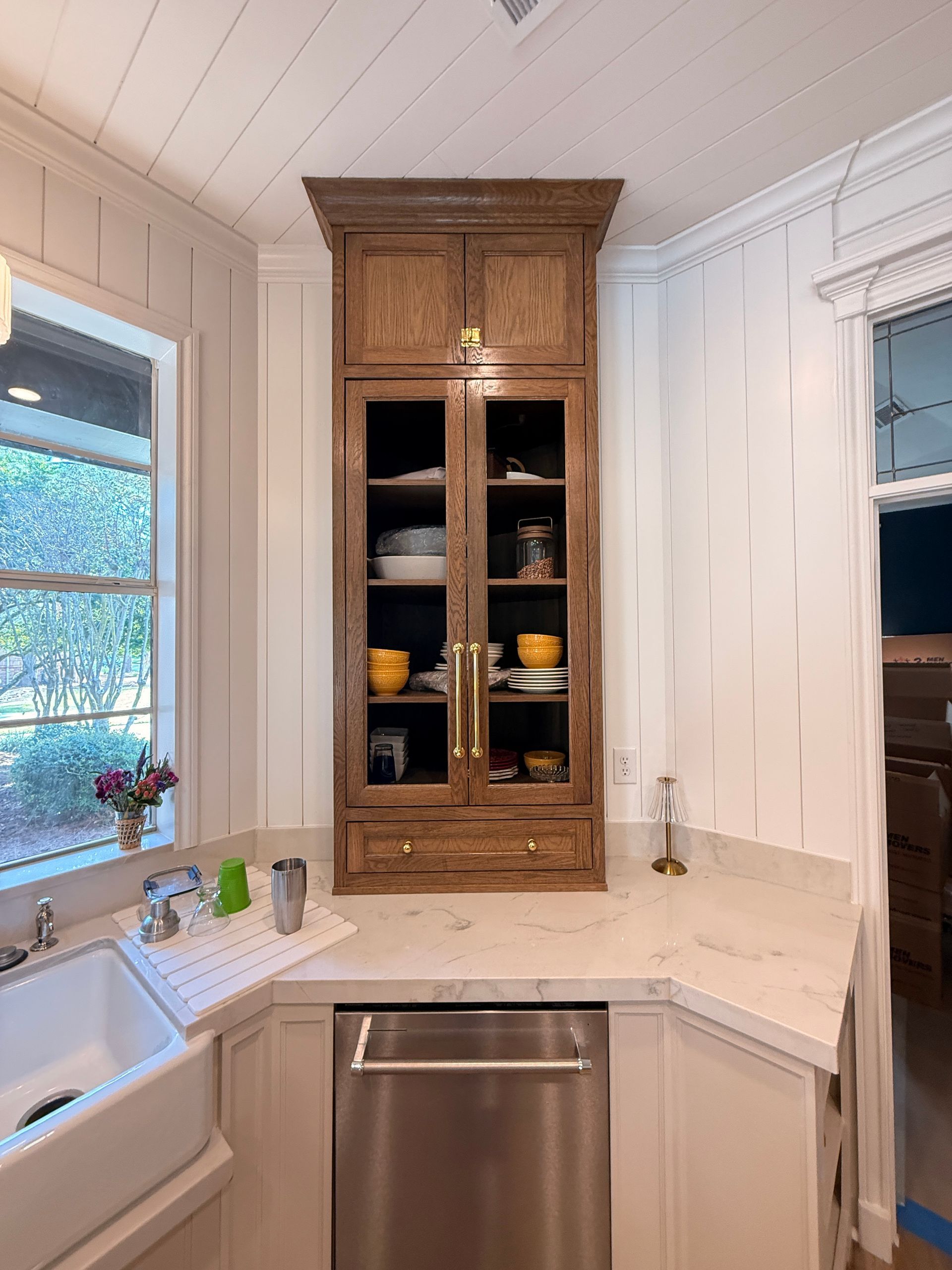 An unfinished wooden bathroom vanity cabinet with several drawers pulled open, sitting on a tiled floor.