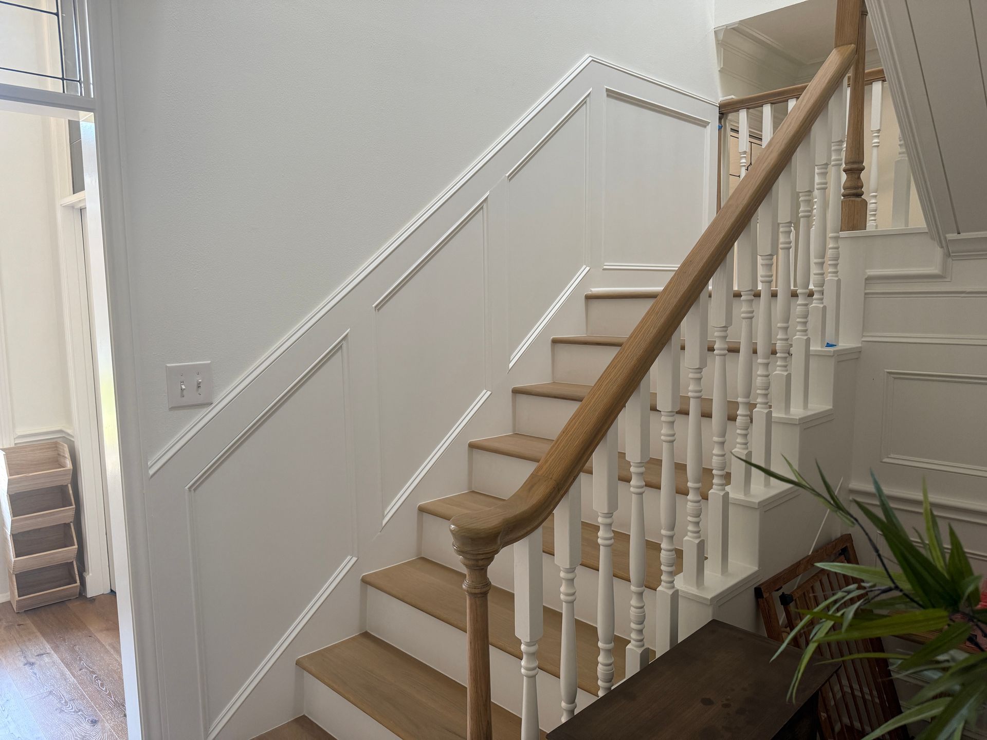 A white doorway frames a view into an unfinished room with exposed ceiling metal framing and gray painted walls.