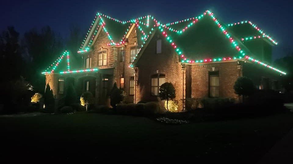 House outlined with colorful Christmas lights at night