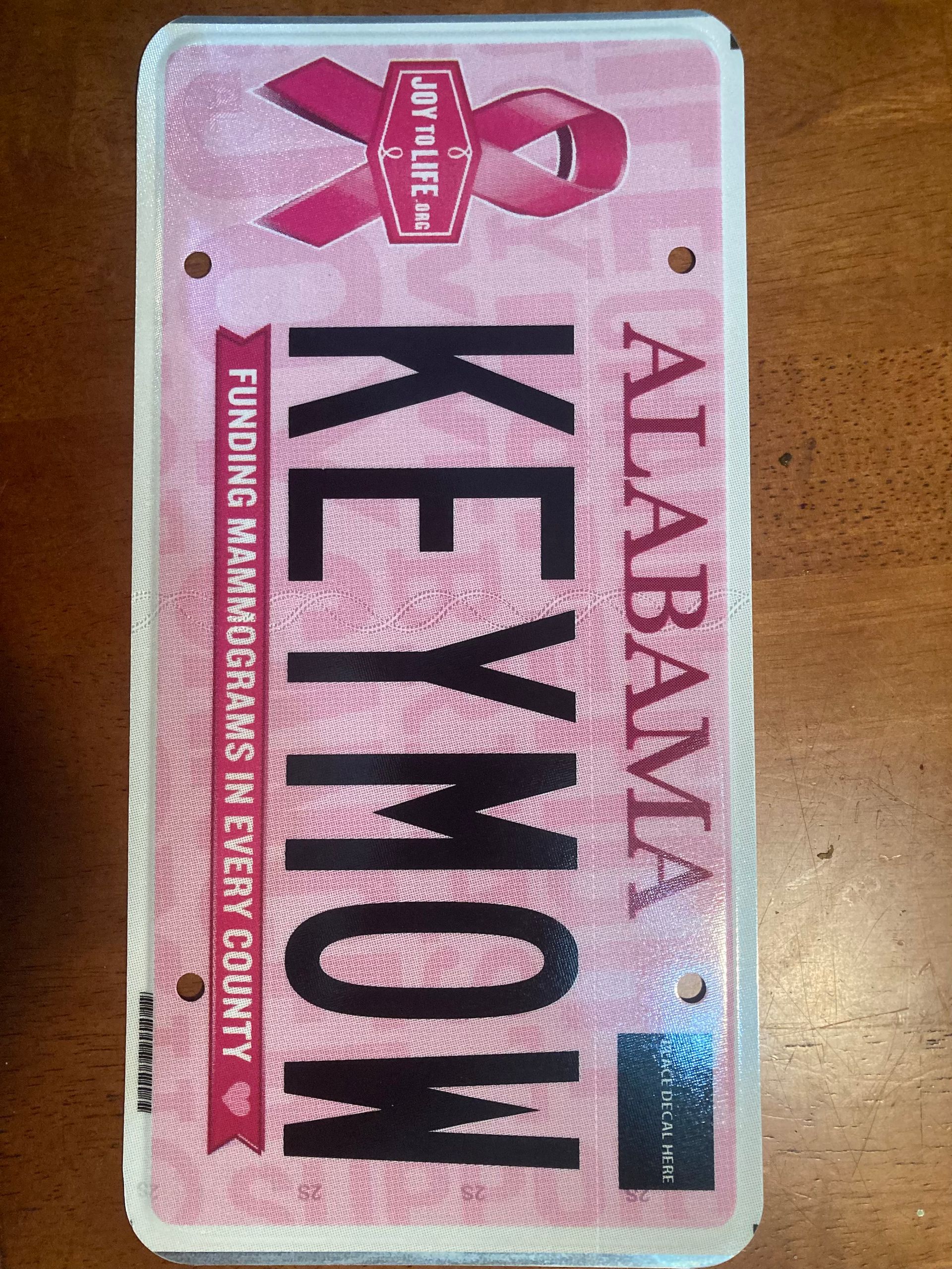 Pink Alabama “KEYMOY” license plate with breast cancer awareness ribbon design
