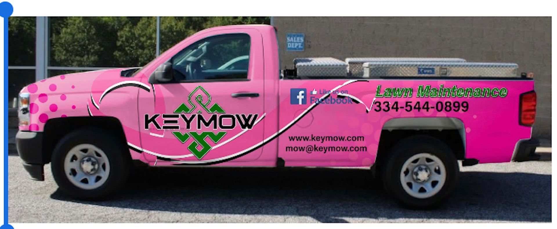 Pink Kymow pickup truck with company branding and phone number on the side