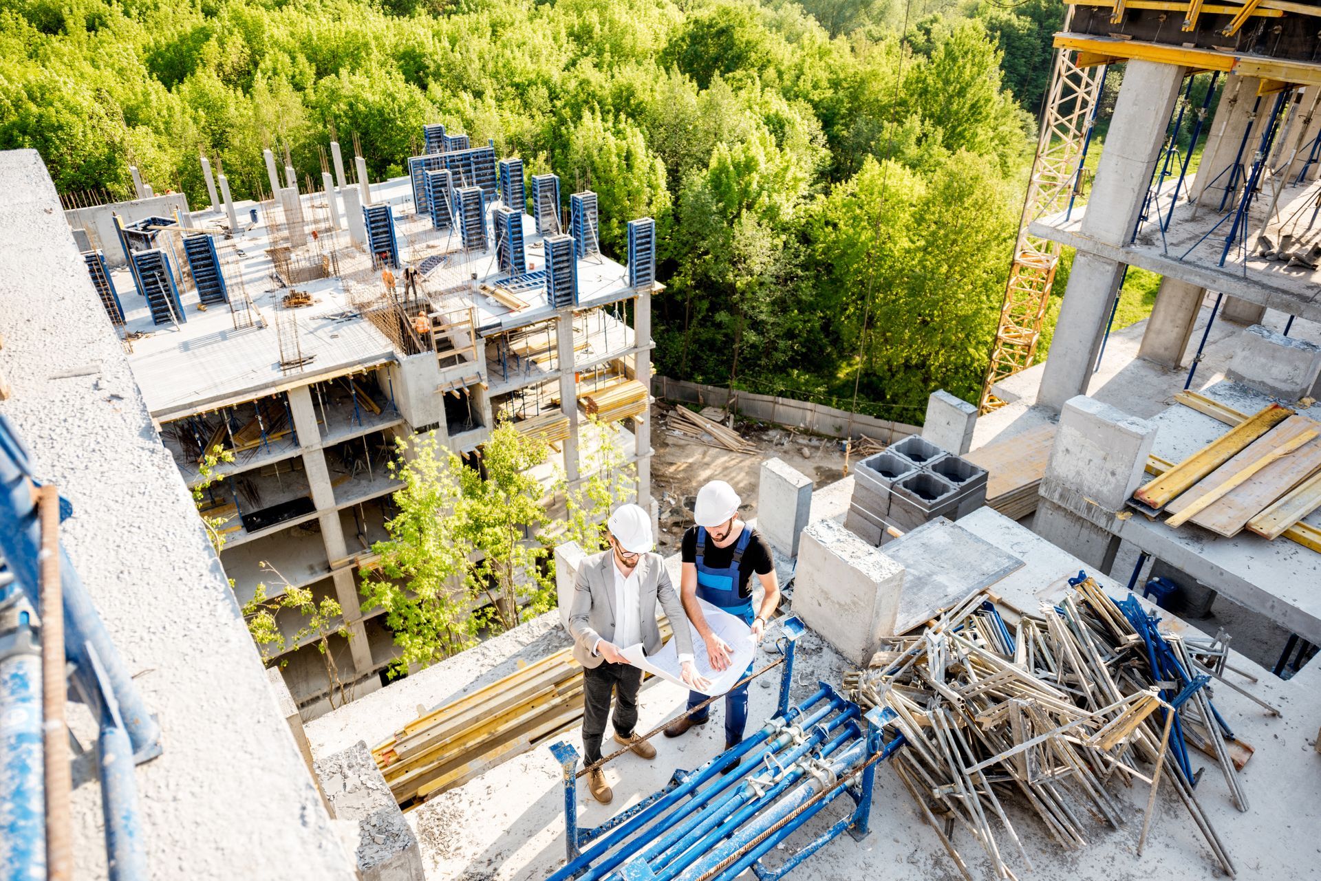 A group of construction workers are standing on top of a building under construction.