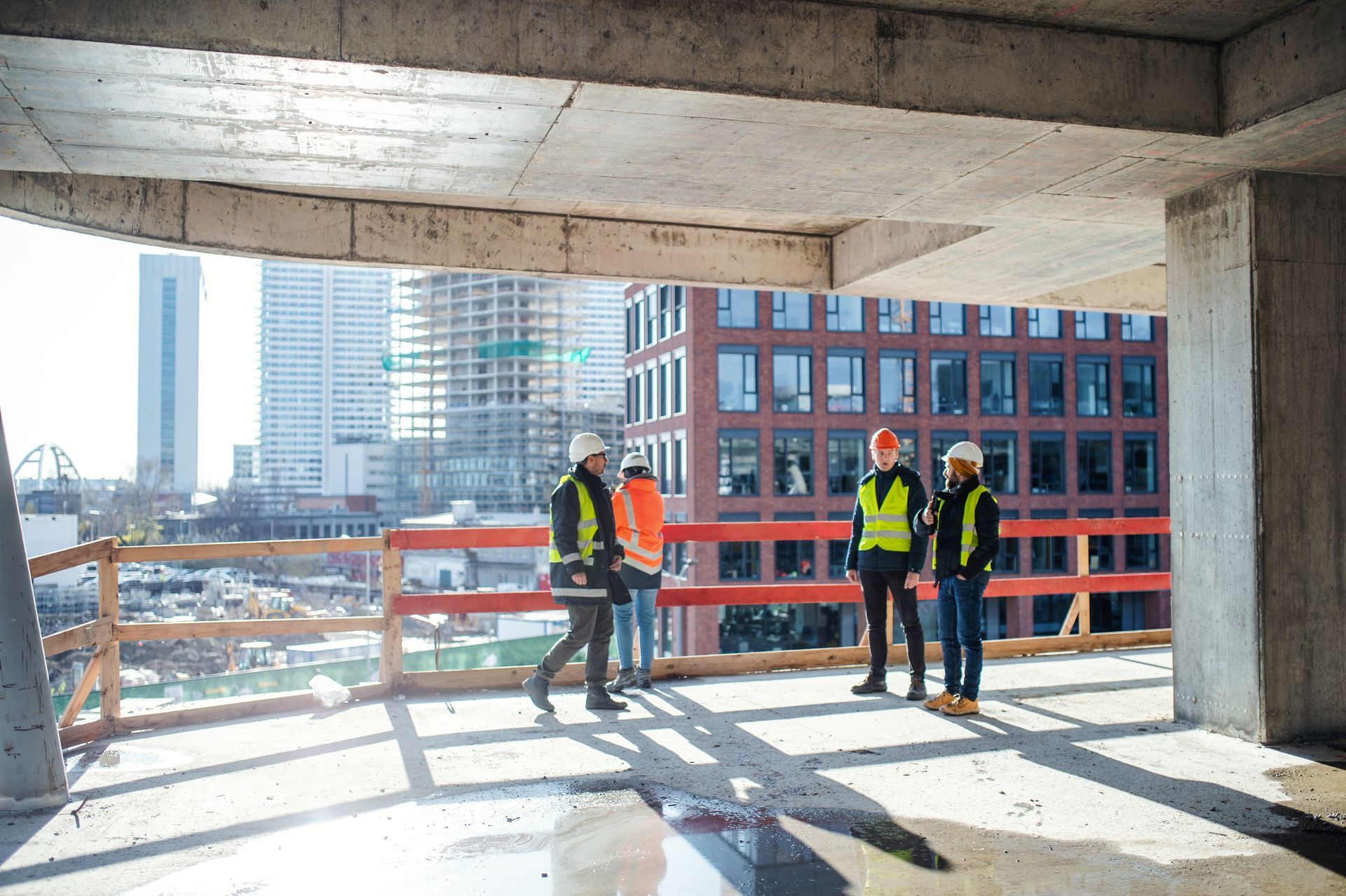A group of construction workers are standing on top of a building under construction.