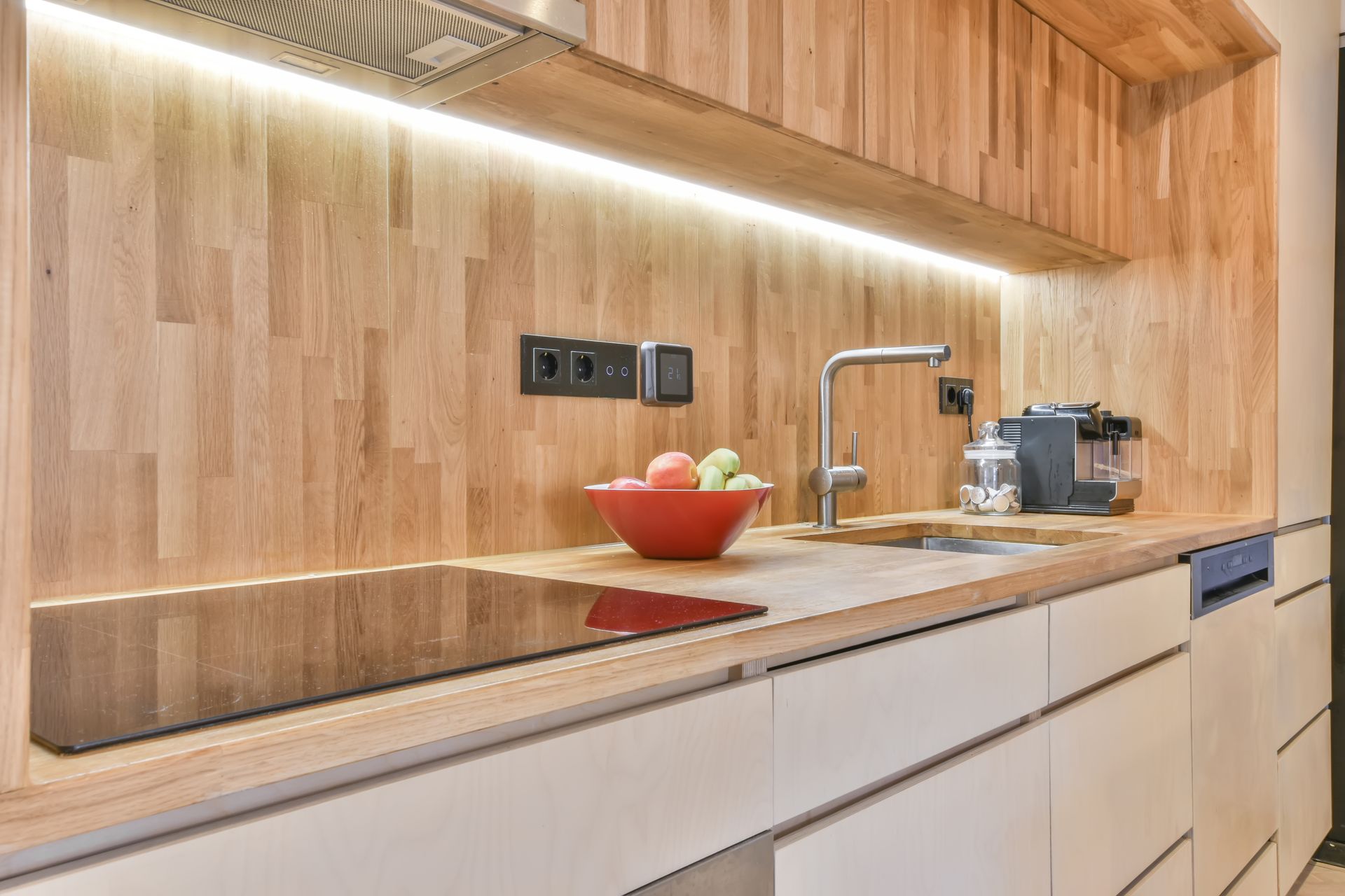 A kitchen with a bowl of fruit on the counter.