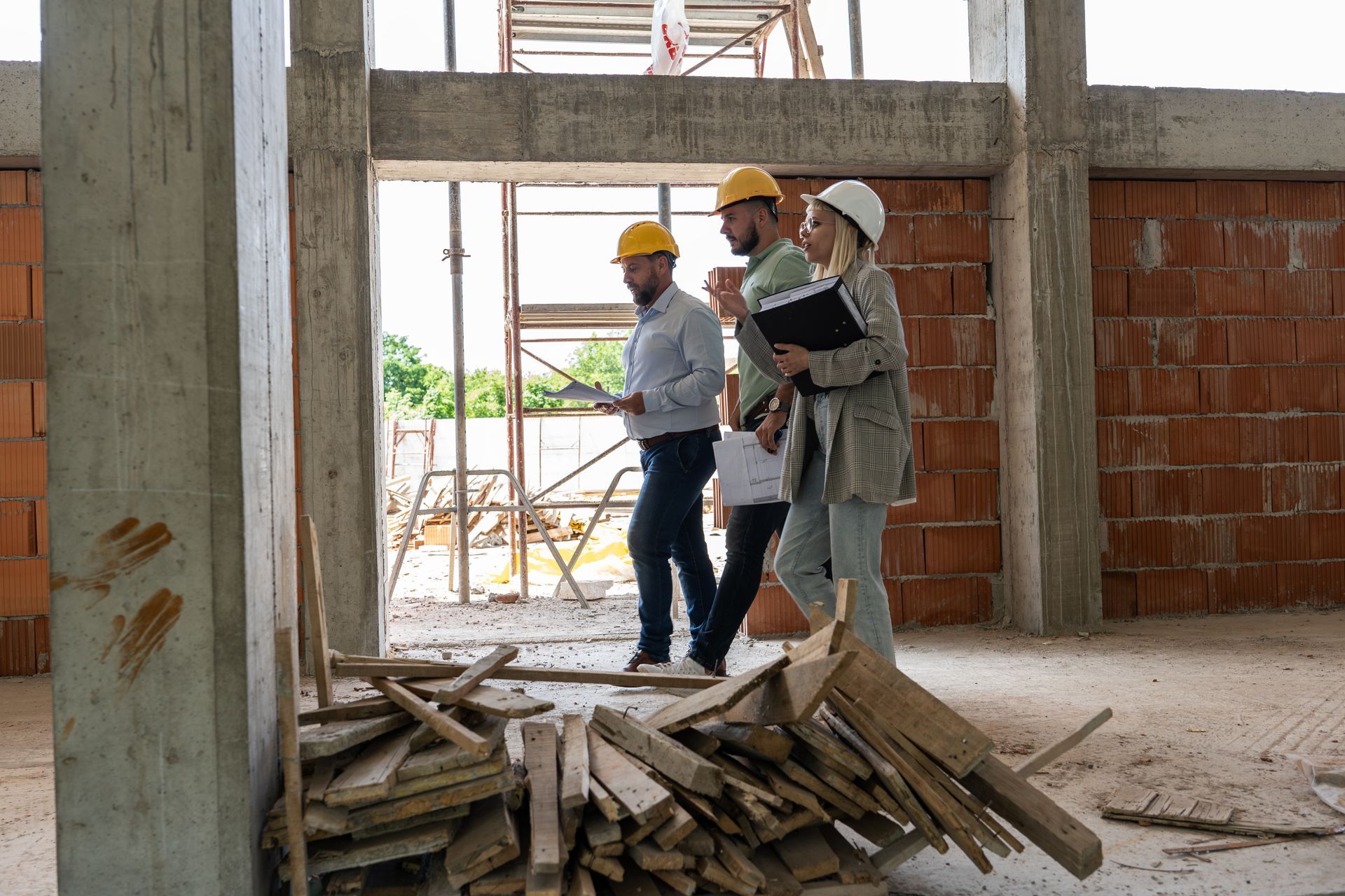 A group of construction workers are standing in a building under construction.