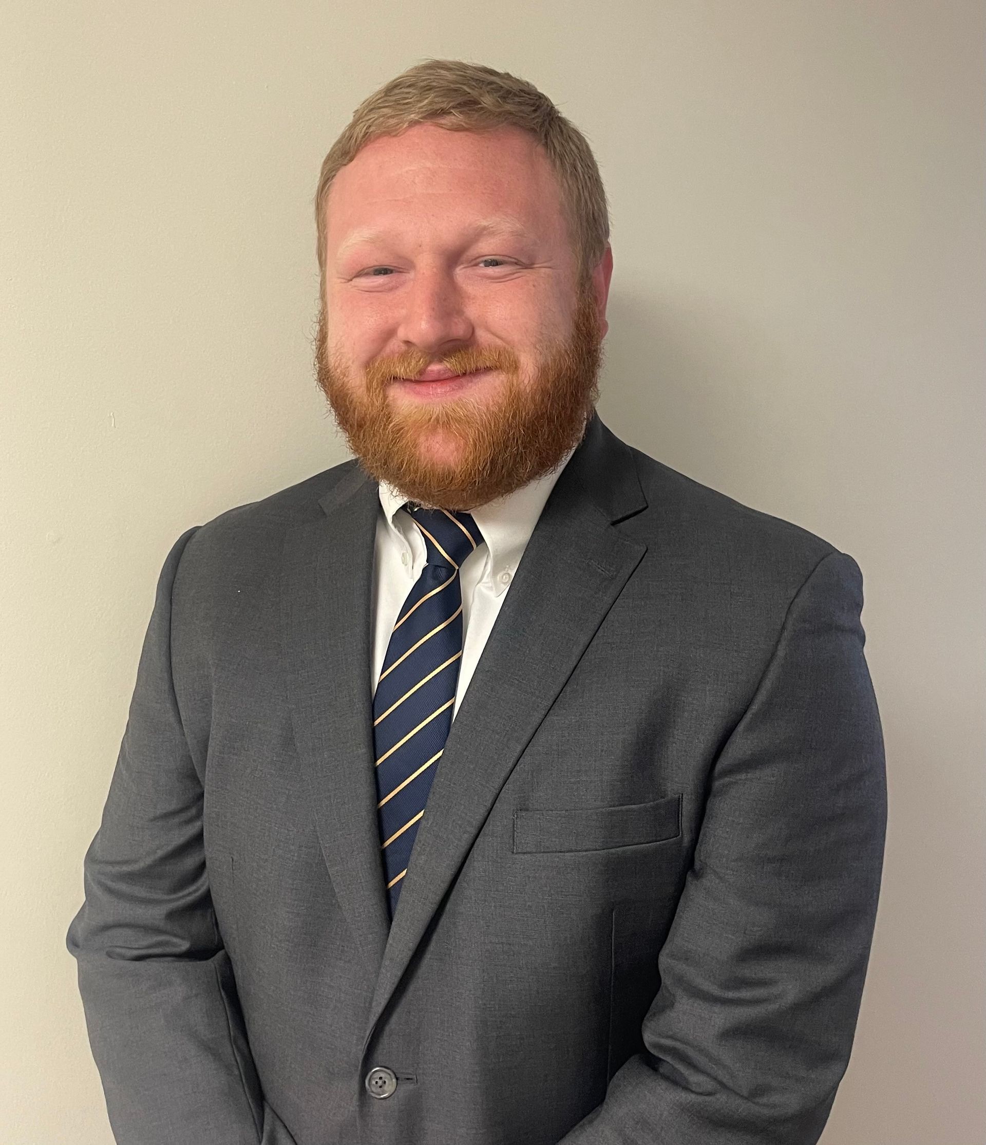 Jessee Hagan in a suit and tie is smiling for the camera.
